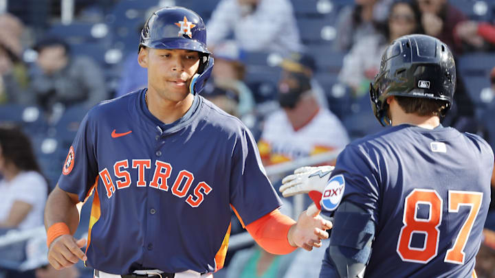 Feb 22, 2025; West Palm Beach, Florida, USA; Houston Astros infielder Cam Smith (left) is congratulated by teammate Tommy Sacco Jr. (87) after scoring a run.