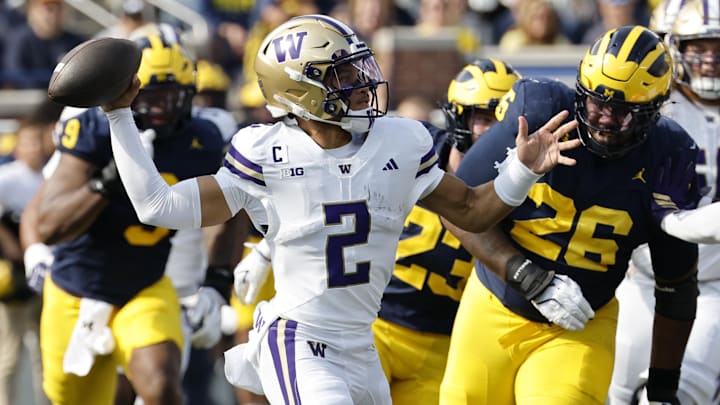 Huskies quarterback Demond Williams Jr. (2) passes with Michigan pass rushers bearing down on him. Huskies quarterback Demond Williams Jr. (2) passes with Michigan pass rushers bearing down on him.