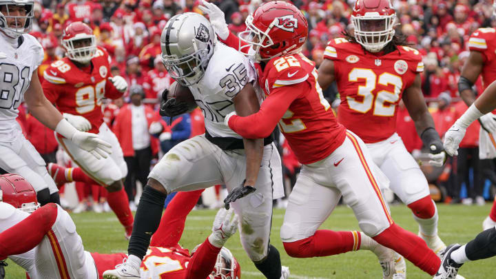 Dec 25, 2023; Kansas City, Missouri, USA; Las Vegas Raiders running back Zamir White (35) runs the ball as Kansas City Chiefs cornerback Trent McDuffie (22) makes the tackle during the game at GEHA Field at Arrowhead Stadium. Mandatory Credit: Denny Medley-USA TODAY Sports