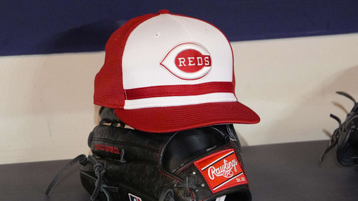 Apr 4, 2025; Milwaukee, Wisconsin, USA; Cincinnati Reds hat and glove rest on the bench in the dugout before a game against the Milwaukee Brewers at American Family Field. Mandatory Credit: Michael McLoone-Imagn Images