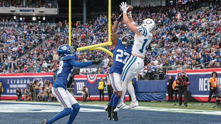 Dec 29, 2024; East Rutherford, New Jersey, USA; Indianapolis Colts wide receiver Alec Pierce (14) catches a touchdown pass as New York Giants safety Jason Pinnock (27) and cornerback Cor'Dale Flott (28) defend during the second half at MetLife Stadium. Mandatory Credit: Vincent Carchietta-Imagn Images