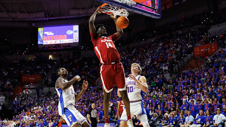 Feb 1, 2026; Gainesville, Florida, USA; Alabama Crimson Tide center Charles Bediako (14) dunks the ball over Florida Gators center Rueben Chinyelu (9) and Florida Gators forward Thomas Haugh (10) during the first half at Exactech Arena at the Stephen C. O'Connell Center. Mandatory Credit: Matt Pendleton-Imagn Images