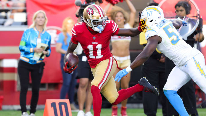 Aug 25, 2023; Santa Clara, California, USA; San Francisco 49ers wide receiver Brandon Aiyuk (11) runs with the ball against Los Angeles Chargers linebacker Amen Ogbongbemiga (57) during the first quarter at Levi's Stadium. Mandatory Credit: Sergio Estrada-USA TODAY Sports