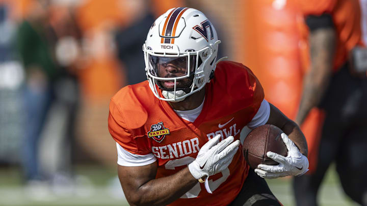 National team running back Bhayshul Tuten of Virginia Tech (33) runs the ball during Senior Bowl practice for the National team at Hancock Whitney Stadium. 