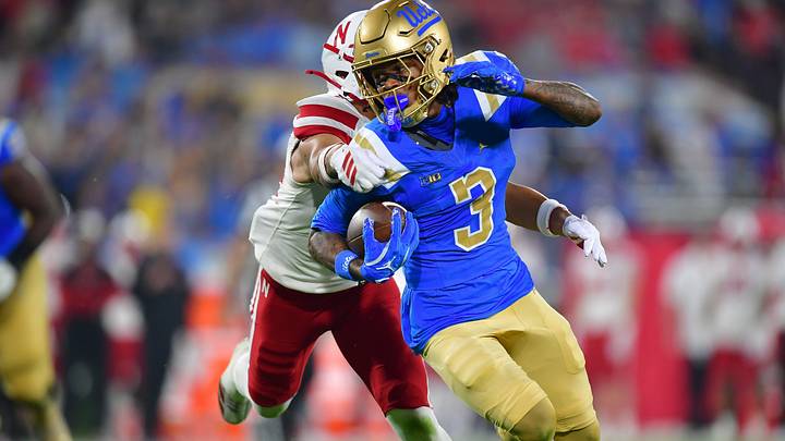 UCLA Bruins wide receiver Kwazi Gilmer runs the ball ahead of Nebraska defensive back Donovan Jones last season. | Gary A. Vasquez-Imagn Images