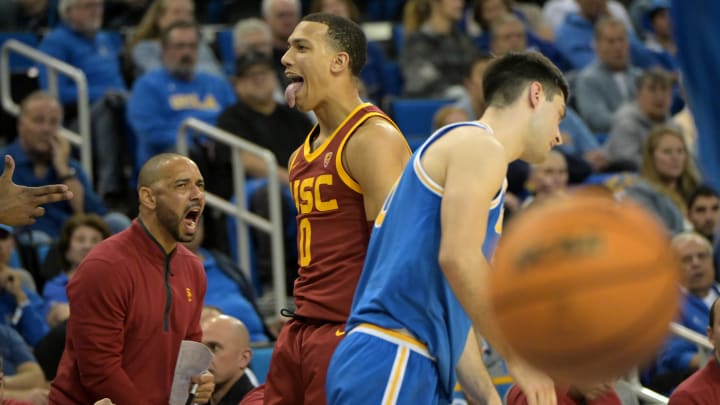Feb 24, 2024; Los Angeles, California, USA;  USC Trojans guard Kobe Johnson (0) reacts after shooting a 3-point basket over UCLA Bruins guard Lazar Stefanovic (10) in the second half at Pauley Pavilion presented by Wescom. Mandatory Credit: Jayne Kamin-Oncea-USA TODAY Sports