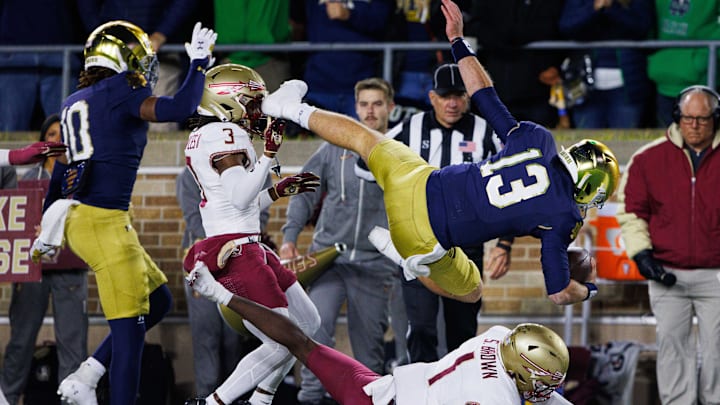 Notre Dame quarterback Riley Leonard (13) leaps over Florida State defensive back Shyheim Brown (1) for a touchdown during a NCAA college football game at Notre Dame Stadium on Saturday, Nov. 9, 2024, in South Bend. Notre Dame quarterback Riley Leonard (13) leaps over Florida State defensive back Shyheim Brown (1) for a touchdown during a NCAA college football game at Notre Dame Stadium on Saturday, Nov. 9, 2024, in South Bend.