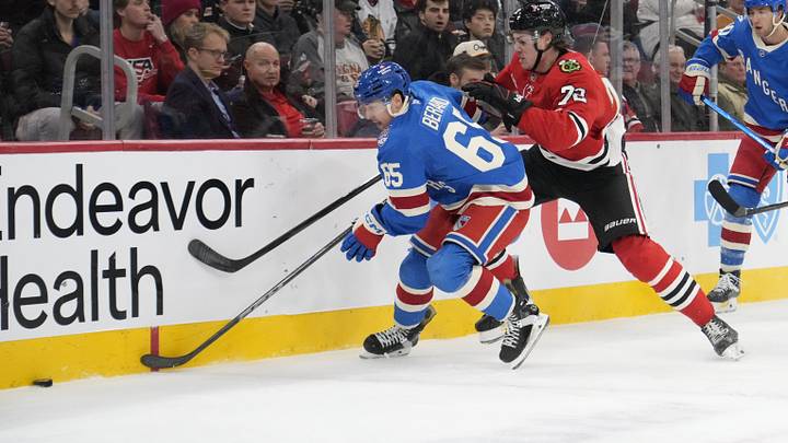 Dec 10, 2025; Chicago, Illinois, USA; New York Rangers left wing Brett Berard (65) and Chicago Blackhawks defenseman Alex Vlasic (72) go for the puck during the first period at United Center. Mandatory Credit: David Banks-Imagn Images