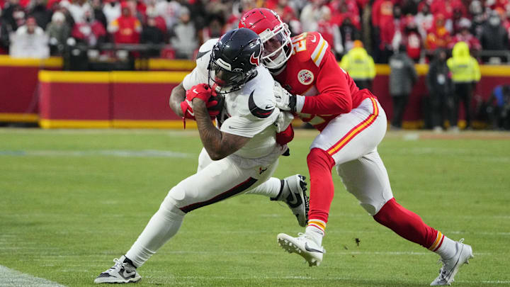 Jan 18, 2025; Kansas City, Missouri, USA; Houston Texans tight end Irv Smith Jr. (83) runs the ball against Kansas City Chiefs safety Justin Reid (20) during the third quarter of a 2025 AFC divisional round game at GEHA Field at Arrowhead Stadium. Mandatory Credit: Denny Medley-Imagn Images