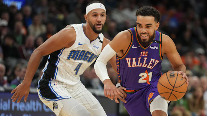 Nov 18, 2024; Phoenix, Arizona, USA; Phoenix Suns guard Tyus Jones (21) drives on Orlando Magic guard Jalen Suggs (4) during the first half of an NBA game at Footprint Center. Mandatory Credit: Rick Scuteri-Imagn Images