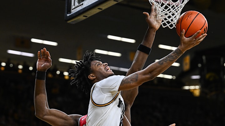 Jan 20, 2026; Iowa City, Iowa, USA; Iowa Hawkeyes guard Tavion Banks (6) goes to the basket as Rutgers Scarlet Knights center Emmanuel Ogbole (21) defends during the 2nd half at Carver-Hawkeye Arena. Mandatory Credit: Jeffrey Becker-Imagn Images