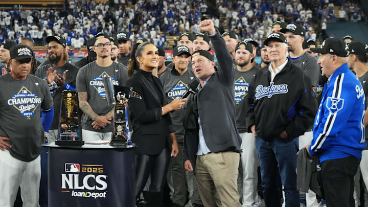 Oct 17, 2025; Los Angeles, California, USA; Los Angeles Dodgers president of baseball operations Andrew Friedman is interviewed by TBS reporter Lauren Shehadi as owner Mark Walter and president Stan Kasten watch after game four of the NLCS round for the 2025 MLB playoffs against the Milwaukee Brewers at Dodger Stadium. Mandatory Credit: Kirby Lee-Imagn Images Oct 17, 2025; Los Angeles, California, USA; Los Angeles Dodgers president of baseball operations Andrew Friedman is interviewed by TBS reporter Lauren Shehadi as owner Mark Walter and president Stan Kasten watch after game four of the NLCS round for the 2025 MLB playoffs against the Milwaukee Brewers at Dodger Stadium. Mandatory Credit: Kirby Lee-Imagn Images