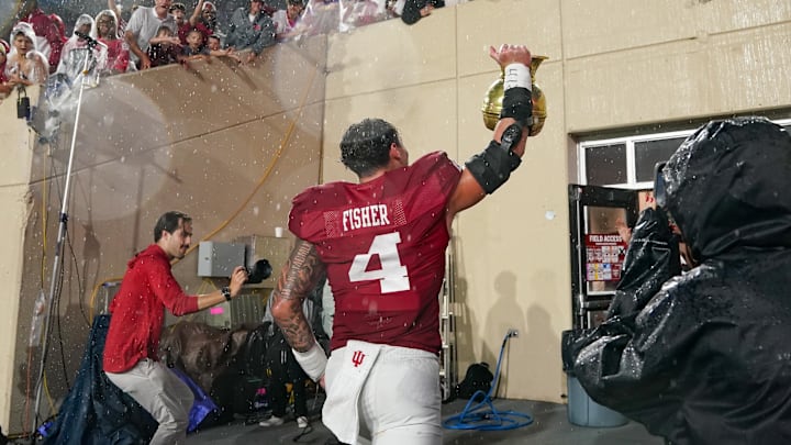Oct 18, 2025; Bloomington, Indiana, USA; Indiana Hoosiers linebacker Aiden Fisher (4) celebrates with the Old Brass Spittoon after the game against the Michigan State Spartans at Memorial Stadium. Mandatory Credit: Robert Goddin-Imagn Images