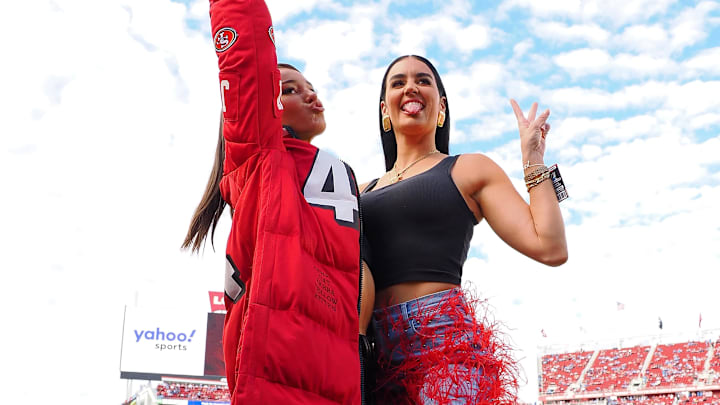 Kristin Juszczyk wears a custom made jacket in show of her support for her husband San Francisco 49ers fullback Kyle Juszczyk (not pictured) as she poses for a photo with Claire Kittle, wife of tight end George Kittle (not pictured).