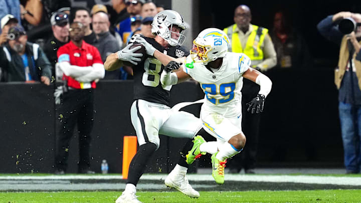 Jan 5, 2025; Paradise, Nevada, USA; Las Vegas Raiders tight end Brock Bowers (89) slips the tackle of Los Angeles Chargers cornerback Tarheeb Still (29) during the fourth quarter at Allegiant Stadium. Mandatory Credit: Stephen R. Sylvanie-Imagn Images