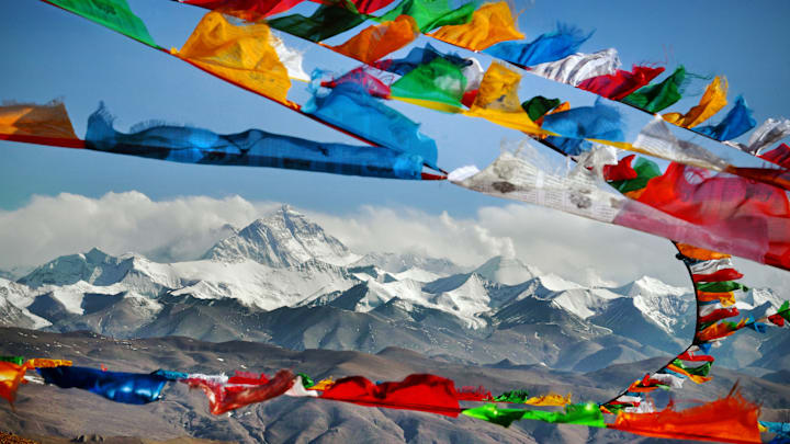 Mount Everest in Himalayas of Tibet viewed at distance through Buddhist prayer flags.