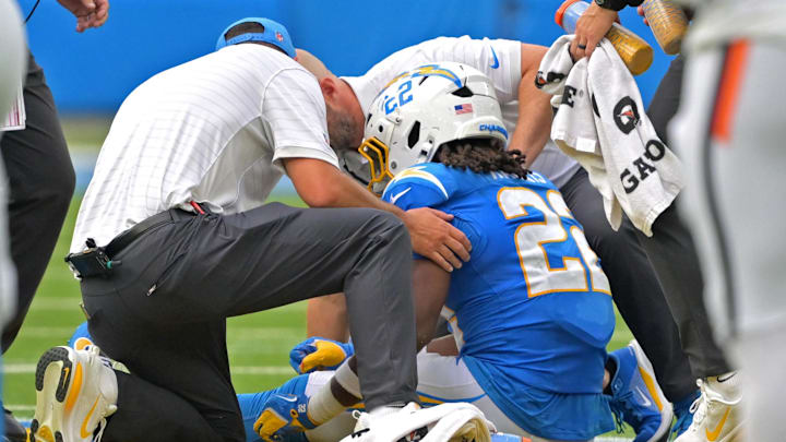 Sep 21, 2025; Inglewood, California, USA;  Dr. Frank Petrigliano, team orthopaedic surgeon, right, and staff check on Los Angeles Chargers running back Najee Harris (22) after an injury in the first half against the Denver Broncos at SoFi Stadium. Mandatory Credit: Jayne Kamin-Oncea-Imagn Images