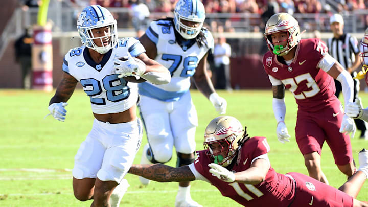 Nov 2, 2024; Tallahassee, Florida, USA;  North Carolina Tarheels running back Omarian Hampton (28) runs the ball past Florida State Seminoles defensive end Patrick Payton (11) during the first quarter at Doak S. Campbell Stadium. Mandatory Credit: Robert Myers-Imagn Images