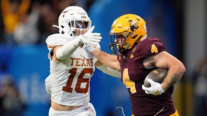 Arizona State Sun Devils running back Cam Skattebo (4) pushes Texas Longhorns defensive back Michael Taaffe (16) away during the second half of the Peach Bowl at Mercedes-Benz Stadium. 