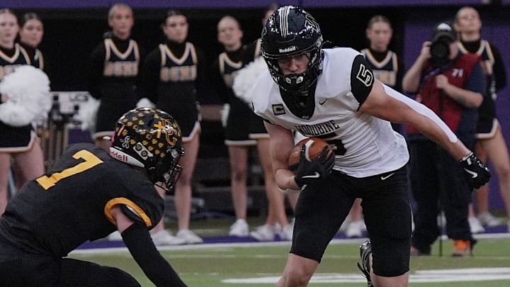 Woodbine wide receiver Landon Blum (5) runs with the ball after making a catch around Bishop Garrigan quarterback/defensive back Tate Foertsch (7) during the first quarter in the 8-players state football championship on Nov. 20, 2025, at UNI Dome in Cedar Falls, Iowa. Woodbine wide receiver Landon Blum (5) runs with the ball after making a catch around Bishop Garrigan quarterback/defensive back Tate Foertsch (7) during the first quarter in the 8-players state football championship on Nov. 20, 2025, at UNI Dome in Cedar Falls, Iowa.