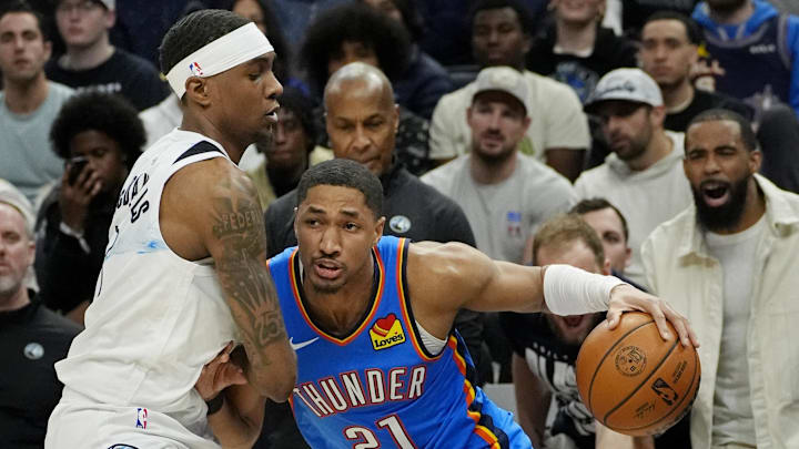 Feb 13, 2025; Minneapolis, Minnesota, USA; Oklahoma City Thunder guard Aaron Wiggins (21) dribbles around Minnesota Timberwolves forward Jaden McDaniels (3) in the first quarter at Target Center.