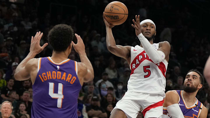 Mar 17, 2025; Phoenix, Arizona, USA; Toronto Raptors guard Immanuel Quickley (5) drives between Phoenix Suns guard Tyus Jones (21) and center Oso Ighodaro (4) in the first half at Footprint Center. Mandatory Credit: Rick Scuteri-Imagn Images Mar 17, 2025; Phoenix, Arizona, USA; Toronto Raptors guard Immanuel Quickley (5) drives between Phoenix Suns guard Tyus Jones (21) and center Oso Ighodaro (4) in the first half at Footprint Center. Mandatory Credit: Rick Scuteri-Imagn Images