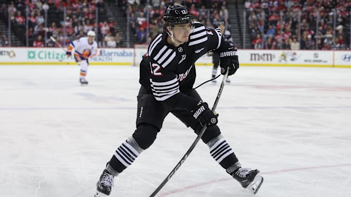 Apr 13, 2025; Newark, New Jersey, USA; New Jersey Devils center Cody Glass (12) shoots the puck against the New York Islanders during the second period at Prudential Center. Mandatory Credit: Ed Mulholland-Imagn Images