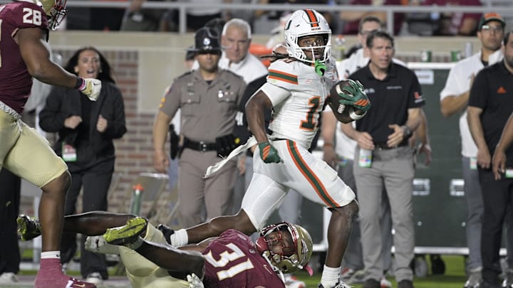 Miami wide receiver Malachi Toney runs as Florida State linebacker Elijah Herring misses the tackle.
