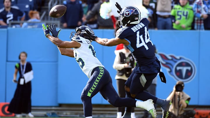 Dec 24, 2023; Nashville, Tennessee, USA; Seattle Seahawks wide receiver Tyler Lockett (16) misses a pass as he is defended by Tennessee Titans safety Mike Brown (44) during the first half at Nissan Stadium. Mandatory Credit: Christopher Hanewinckel-Imagn Images