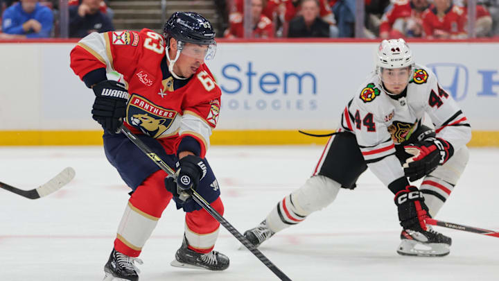 Oct 7, 2025; Sunrise, Florida, USA; Florida Panthers left wing Brad Marchand (63) moves the puck against Chicago Blackhawks defenseman Wyatt Kaiser (44) during the first period at Amerant Bank Arena. Mandatory Credit: Sam Navarro-Imagn Images