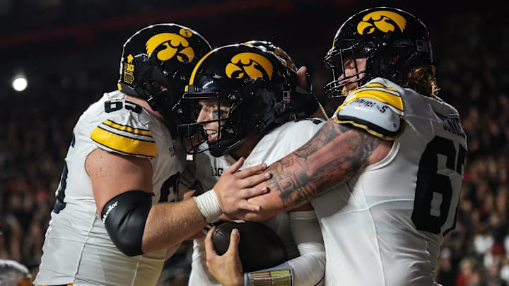 Sep 19, 2025; Piscataway, New Jersey, USA; Iowa Hawkeyes quarterback Mark Gronowski (11) celebrates with teammates after scoring a rushing touchdown during the first half against the Rutgers Scarlet Knights at SHI Stadium. Mandatory Credit: Vincent Carchietta-Imagn Images