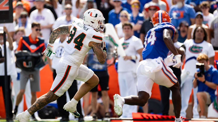 Aug 31, 2024; Gainesville, Florida, USA; Miami Hurricanes tight end Cam McCormick (84) runs the ball for a touchdown against Florida Gators defensive back Jordan Castell (14) during the first half at Ben Hill Griffin Stadium. Mandatory Credit: Matt Pendleton-Imagn Images Aug 31, 2024; Gainesville, Florida, USA; Miami Hurricanes tight end Cam McCormick (84) runs the ball for a touchdown against Florida Gators defensive back Jordan Castell (14) during the first half at Ben Hill Griffin Stadium. Mandatory Credit: Matt Pendleton-Imagn Images