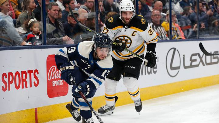 Oct 28, 2022; Columbus, Ohio, USA; Columbus Blue Jackets left wing Johnny Gaudreau (13) and Boston Bruins center Patrice Bergeron (37) play for the puck during the second period at Nationwide Arena. Mandatory Credit: Russell LaBounty-USA TODAY Sports