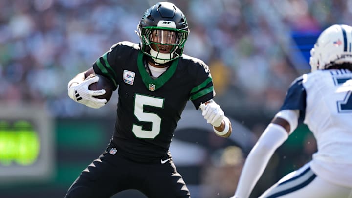 Oct 5, 2025; East Rutherford, New Jersey, USA; New York Jets wide receiver Garrett Wilson (5) carries the ball after the catch against the Dallas Cowboys during the first half at MetLife Stadium.