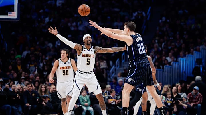 Orlando Magic forward Franz Wagner (22) passes the ball as Denver Nuggets guard Kentavious Caldwell-Pope (5) guards in the second quarter at Ball Arena. 