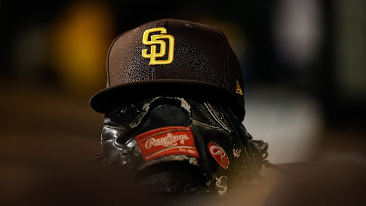 Jun 17, 2022; Denver, Colorado, USA; A detail view of a San Diego Padres hat on a glove in the dugout in the ninth inning against the Colorado Rockies at Coors Field. Mandatory Credit: Isaiah J. Downing-Imagn Images Jun 17, 2022; Denver, Colorado, USA; A detail view of a San Diego Padres hat on a glove in the dugout in the ninth inning against the Colorado Rockies at Coors Field. Mandatory Credit: Isaiah J. Downing-Imagn Images