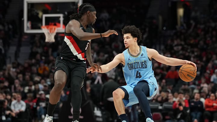 Feb 7, 2026; Portland, Oregon, USA; Memphis Grizzlies guard Walter Clayton Jr. (4) handles the ball against Portland Trail Blazers guard Jrue Holiday (5) during the second half at Moda Center. Mandatory Credit: Soobum Im-Imagn Images