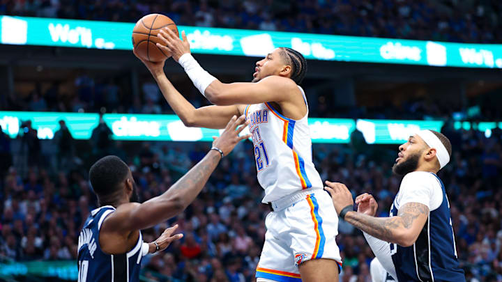 May 11, 2024; Dallas, Texas, USA; Oklahoma City Thunder guard Aaron Wiggins (21) shoots as Dallas Mavericks center Daniel Gafford (21) and Dallas Mavericks forward Tim Hardaway Jr. (10) defend during the second half during game three of the second round for the 2024 NBA playoffs at American Airlines Center. Mandatory Credit: Kevin Jairaj-Imagn Images