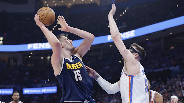 Mar 10, 2025; Oklahoma City, Oklahoma, USA; Denver Nuggets center Nikola Jokic (15) shoots as Oklahoma City Thunder center Isaiah Hartenstein (55) defends during the first quarter at Paycom Center. Mandatory Credit: Alonzo Adams-Imagn Images