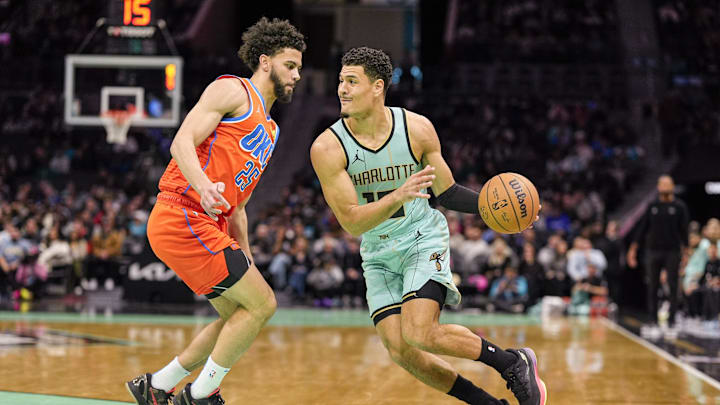 Dec 28, 2024; Charlotte, North Carolina, USA; Charlotte Hornets guard Josh Green (10) drives to the basket against Oklahoma City Thunder guard Ajay Mitchell (25) during the first quarter at Spectrum Center. Mandatory Credit: Jim Dedmon-Imagn Images