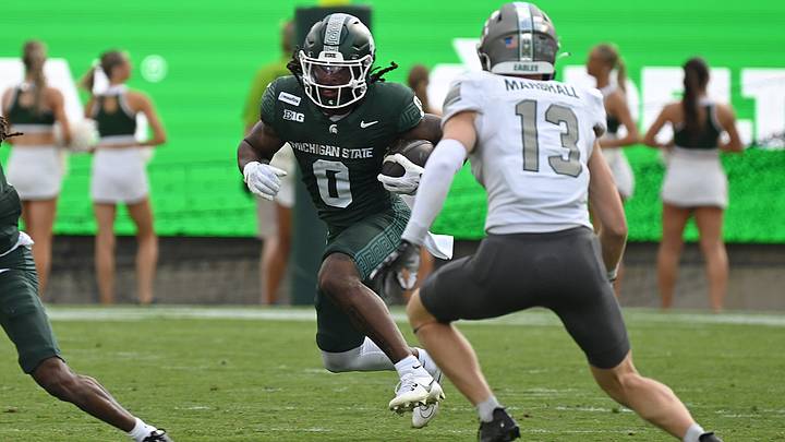 Sep 12, 2026; East Lansing, Michigan, USA; Michigan State Spartans running back Cam Edwards (0) runs for extra yards against the Eastern Michigan Eagles during the first quarter at Spartan Stadium. Mandatory Credit: Dale Young-Imagn Images Sep 12, 2026; East Lansing, Michigan, USA; Michigan State Spartans running back Cam Edwards (0) runs for extra yards against the Eastern Michigan Eagles during the first quarter at Spartan Stadium. Mandatory Credit: Dale Young-Imagn Images