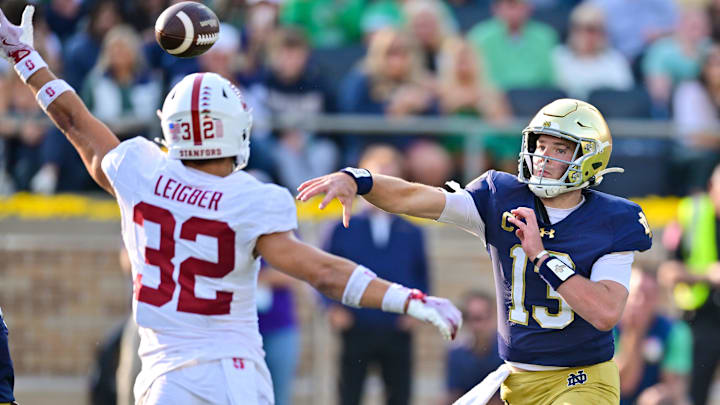 Oct 12, 2024; South Bend, Indiana, USA; Notre Dame Fighting Irish quarterback Riley Leonard (13) throws a pass for a touchdown as Stanford Cardinal safety Mitch Leigber (32) defends in the second quarter at Notre Dame Stadium. Mandatory Credit: Matt Cashore-Imagn Images