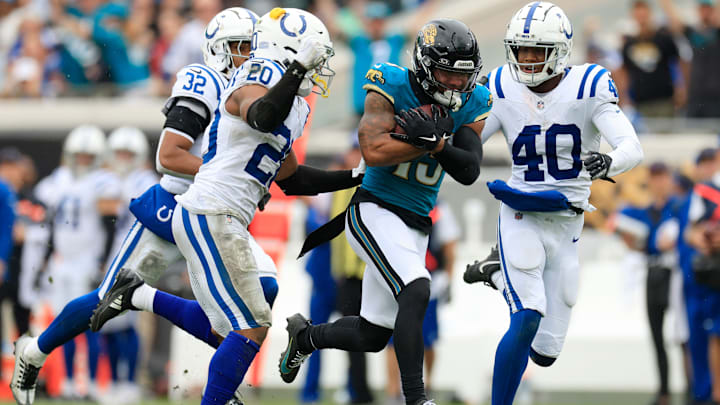 Jacksonville Jaguars wide receiver Christian Kirk (13) rushes for yards against Indianapolis Colts safety Nick Cross (20) and cornerback Jaylon Jones (40) during the fourth quarter of an NFL football matchup Sunday, Oct. 6, 2024 at EverBank Stadium in Jacksonville, Fla. The Jaguars edged the Colts on a field goal 37-34. [Corey Perrine/Florida Times-Union]