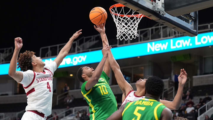 Dec 21, 2024; San Jose, California, USA; Oregon Ducks forward Kwame Evans Jr. (10) shoots against Stanford Cardinal guard Oziyah Sellers (4) and guard Ryan Agarwal (obscured right) during the second half at SAP Center at San Jose.
