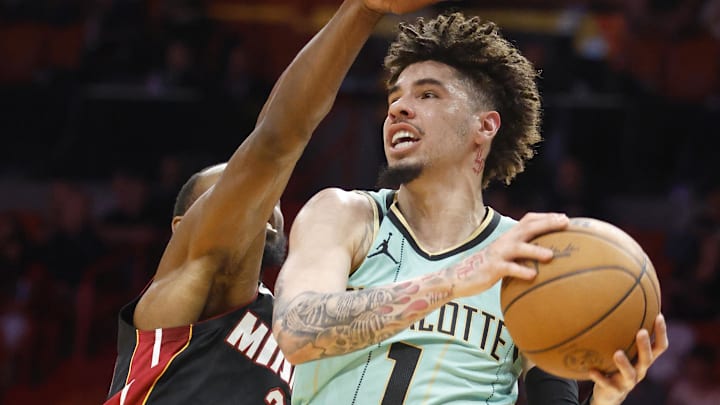 Mar 23, 2025; Miami, Florida, USA; Charlotte Hornets guard LaMelo Ball (1) is defended by Miami Heat forward Andrew Wiggins (22) during the first half at Kaseya Center. Mandatory Credit: Rhona Wise-Imagn Images
