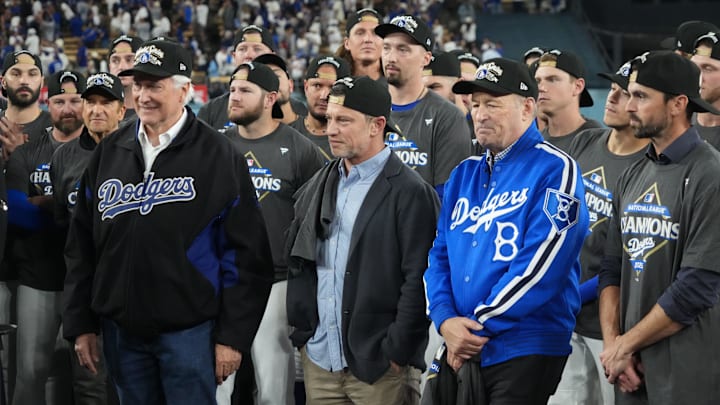 Oct 17, 2025; Los Angeles, California, USA; Los Angeles Dodgers owner Mark Walter, president of baseball operations Andrew Friedman and president Stan Kasten react after game four of the NLCS round for the 2025 MLB playoffs against the Milwaukee Brewers at Dodger Stadium. Mandatory Credit: Kirby Lee-Imagn Images Oct 17, 2025; Los Angeles, California, USA; Los Angeles Dodgers owner Mark Walter, president of baseball operations Andrew Friedman and president Stan Kasten react after game four of the NLCS round for the 2025 MLB playoffs against the Milwaukee Brewers at Dodger Stadium. Mandatory Credit: Kirby Lee-Imagn Images