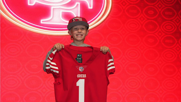 Feb 11, 2023; Phoenix, AZ, USA; Brady Wright poses with San Francisco 49ers jersey at the NFL Draft exhibit at the Super Bowl LVII Experience at the Phoenix Convention Center.  Mandatory Credit: Kirby Lee-Imagn Images