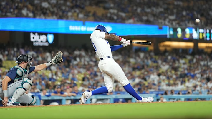 Aug 20, 2024; Los Angeles, California, USA;  Los Angeles Dodgers right fielder Jason Heyward (23) hits a three-run home run in the eighth inning as Seattle Mariners catcher Cal Raleigh (29) watches at Dodger Stadium. Mandatory Credit: Kirby Lee-Imagn Images