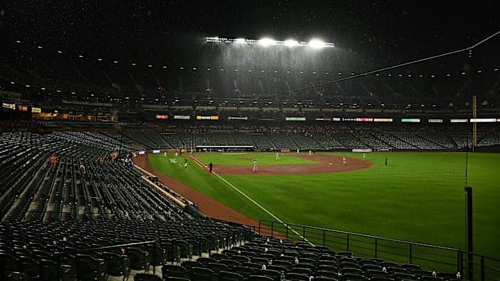 Jul 25, 2025; Baltimore, Maryland, USA;  Baltimore Orioles and Colorado Rockies play through the rain during the fifth inning at Oriole Park at Camden Yards. Mandatory Credit: James A. Pittman-Imagn Images