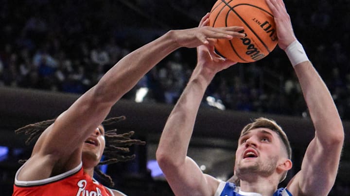 Dec 21, 2024; New York, New York, USA; Kentucky Wildcats forward Andrew Carr (7) shoots the ball while being defended by Ohio State Buckeyes forward Devin Royal (21) during the first half at Madison Square Garden. Mandatory Credit: John Jones-Imagn Images